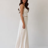 This is the Conrad Set in Ivory. This is a two piece satin set with a fitted, corseted top with thick straps and a delicate tie at the bust and a slight basque waist. It comes with a floor length satin column skirt.