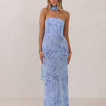 Model wearing a strapless chiffon blue floral dress with a matching scarf. 