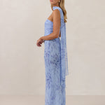 Model wearing a strapless chiffon blue floral dress with a matching scarf. 