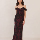 Woman wearing a black and dark red floral off-shoulder gown on a white background