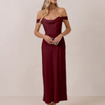 Woman wearing a burgundy off-shoulder dress against a plain background